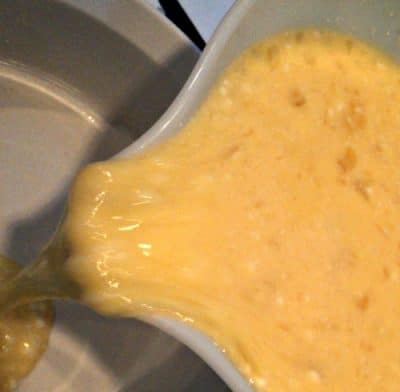 quiche mixture pouring into baking dish