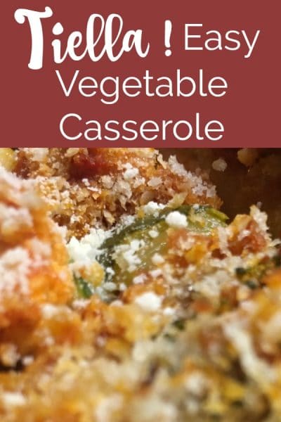 Layered vegetable casserole topped with bread crumbs and cheese.