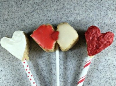 Three red and white heart shaped Rice Krispies Popsicles.