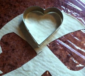 Cutting a heart shaped tortilla with a heart cookie cutter.