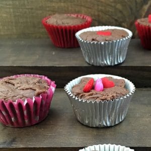 Silver cupcake liners filled with fudge and decorated with red hearts.