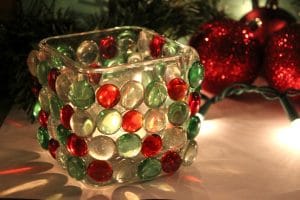 Red, white, green clear jewels on glass candle jar.