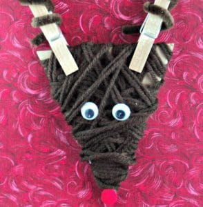Reindeer ornament made of yarn and clothespin antlers.