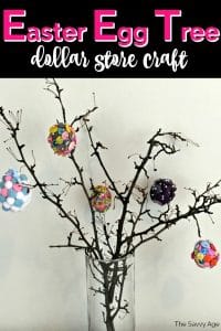 Branches in a clear glass vase decorated with fake colorful Easter eggs.
