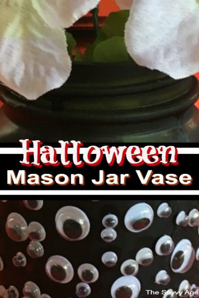 Black mason jar vase adorned with googly eyes for Halloween.