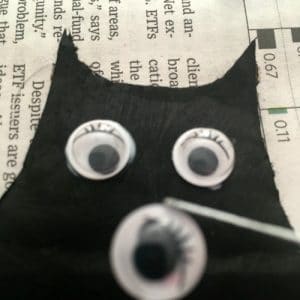 tweezer placing googly eye on black paper bat