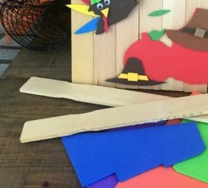 Paint sticks, craft paper next to a paint stick turkey.