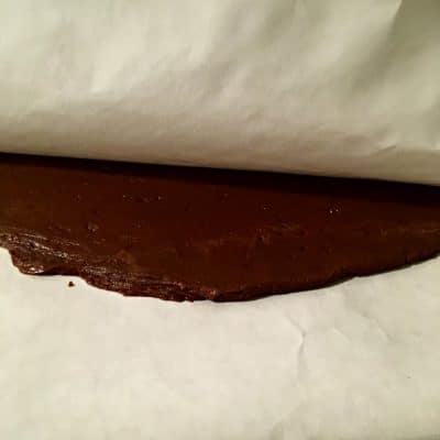 Smooth fudge between two layers of parchment paper.