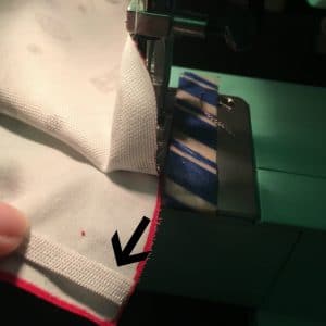 Edge of elastic band lined up with edge of fabric.