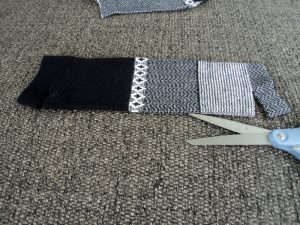 Black and white sock with one cut from edge of sock.