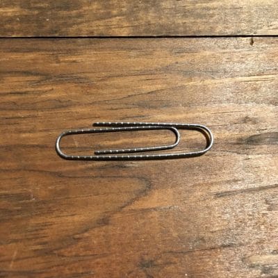 Jumbo paper clip on wood.