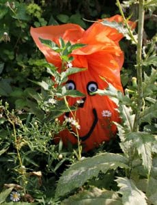 Recycled pumpkin made from plastic orange table cloth and black foam paper for the cut out face.