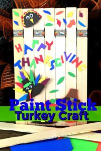 Paint stick made into a fence with turkey and Fall colorful construction paper decorations.